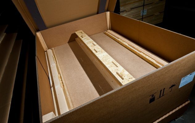 Geöffnete Kartonverpackung mit stabilisierender Holzkonstruktion im Inneren