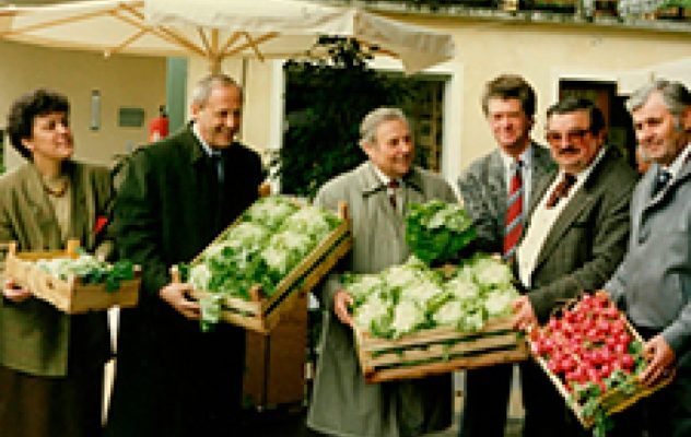 Historische Aufnahme einer Besuchergruppe mit gefüllten Holzkisten