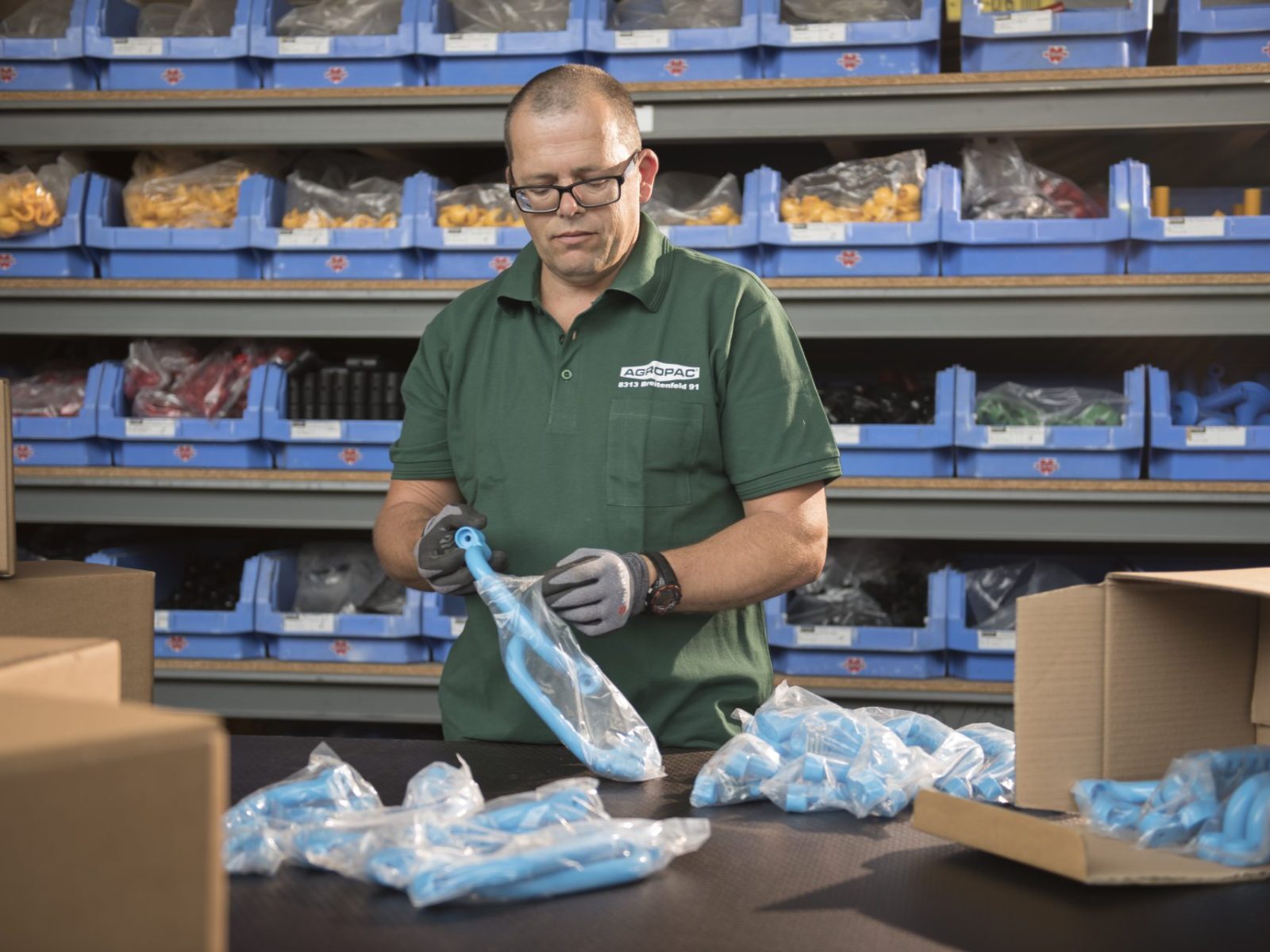 Mitarbeiter verpackt Bauteile in Schutzbeuteln und Kartons